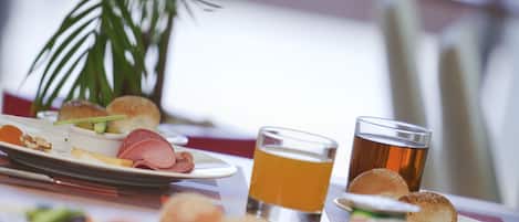 Una mesa con platos de comida, incluyendo sándwiches y una taza de té.