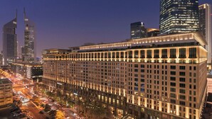 A high-rise hotel with multiple floors, large windows, and a well-lit facade.