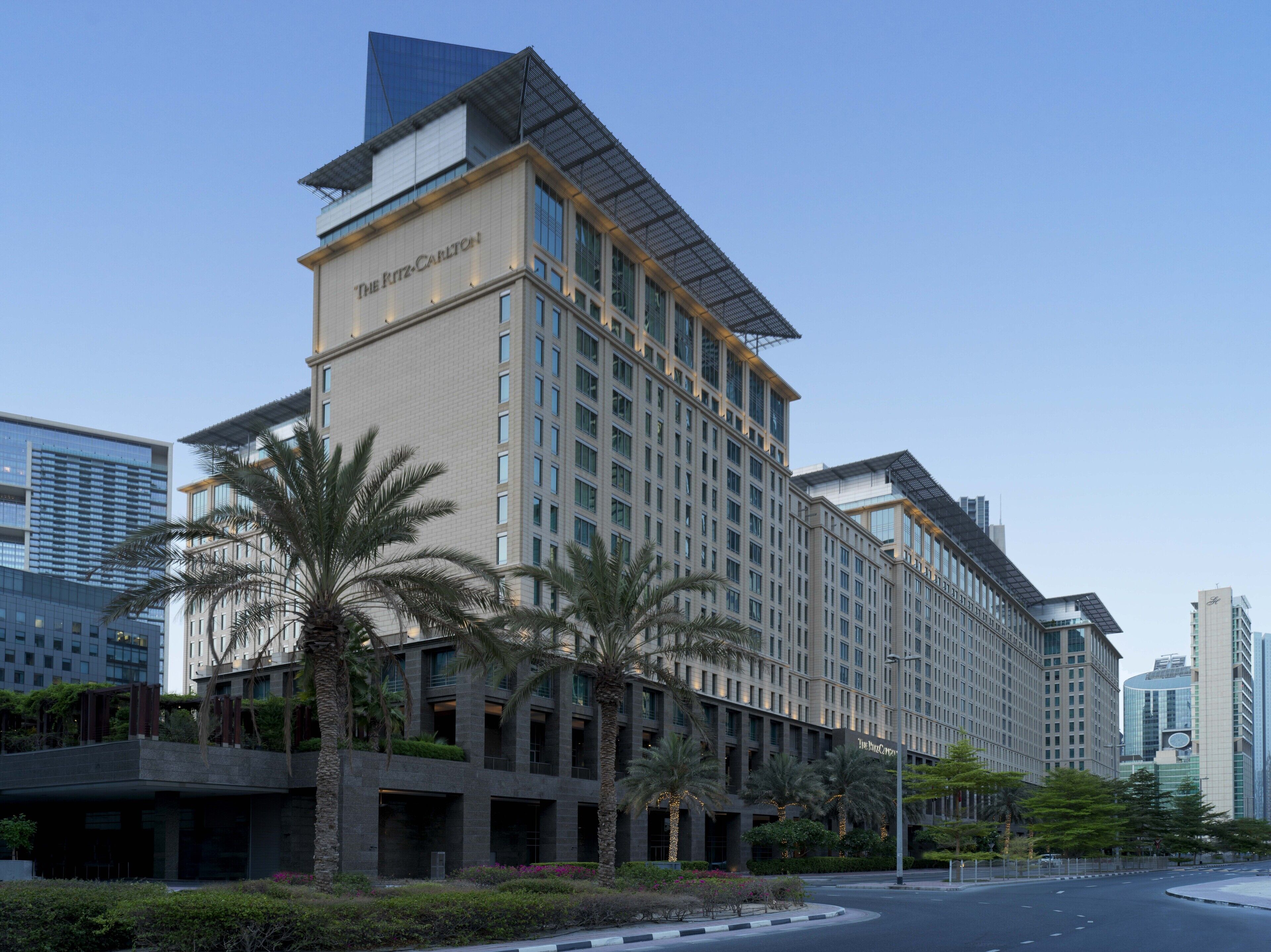 Un hotel moderno con un letrero llamativo, varios pisos y una estructura en la azotea.