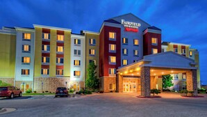 A multi-story hotel with a Marriott Fairfield Inn & Suites sign, featuring a central entrance with a covered walkway, multiple parking spaces, and a well-lit facade. - Fairfield Inn & Suites Oklahoma City Airport (Oklahoma City)
