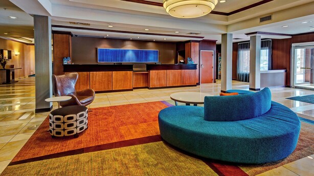 A modern lobby with a reception desk, seating area, and a large window. - Fairfield Inn & Suites Oklahoma City Airport (Oklahoma City)