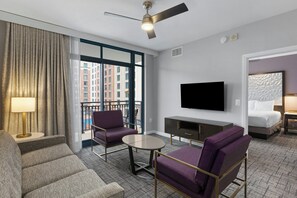 A hotel room with a sofa, armchair, TV, and a bed. - Club Wyndham National Harbor (Oxon Hill)