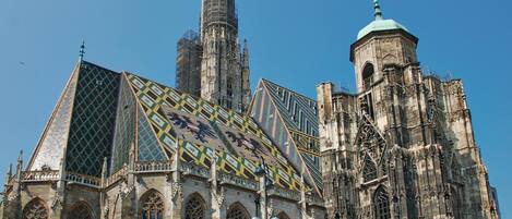 A historic cathedral with intricate Gothic architecture, featuring tall spires, detailed stonework, and large stained glass windows.