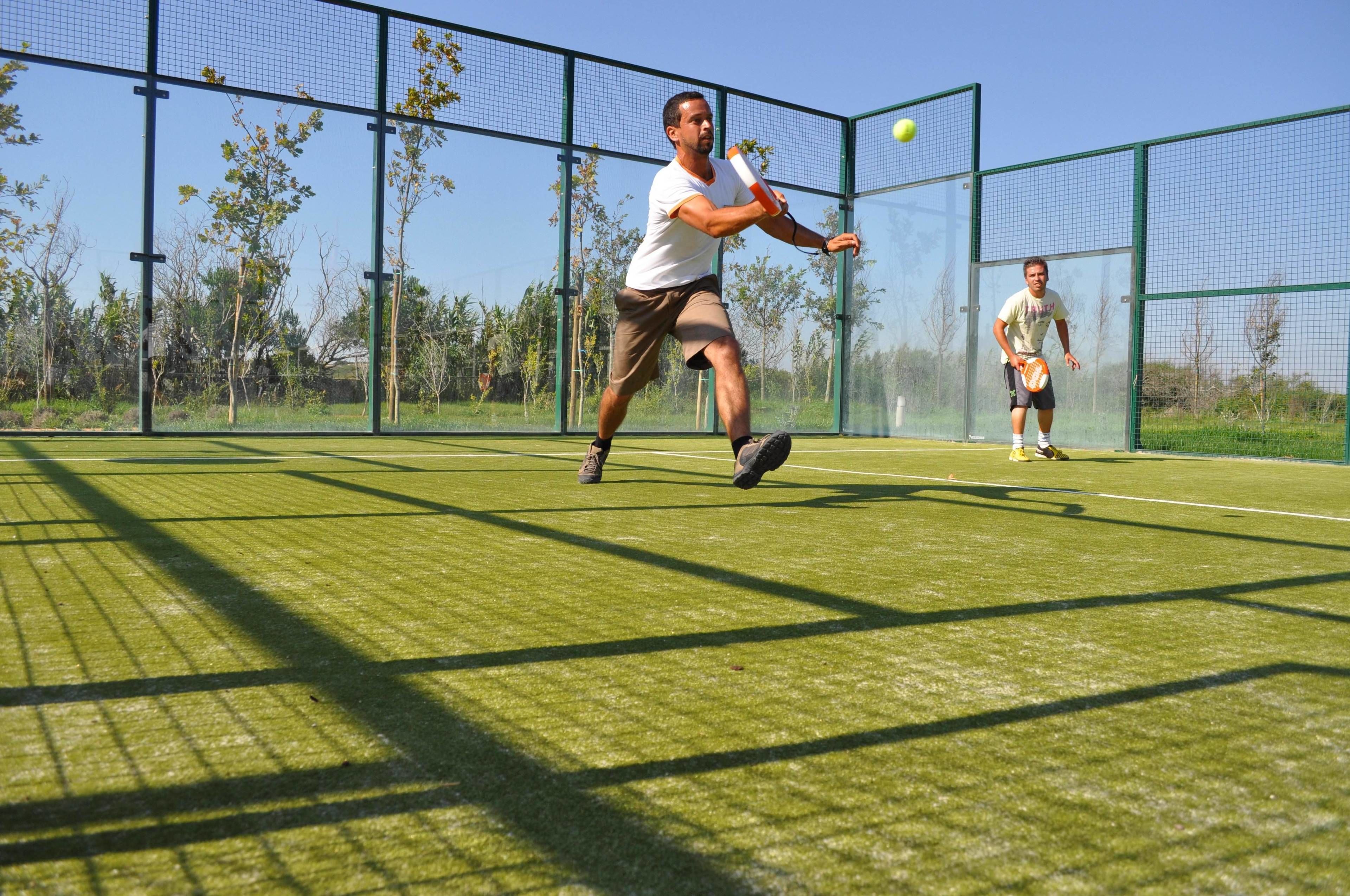Una cancha de tenis con una red y un jugador en juego.