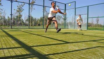 Una cancha de tenis con una red y un jugador en juego.
