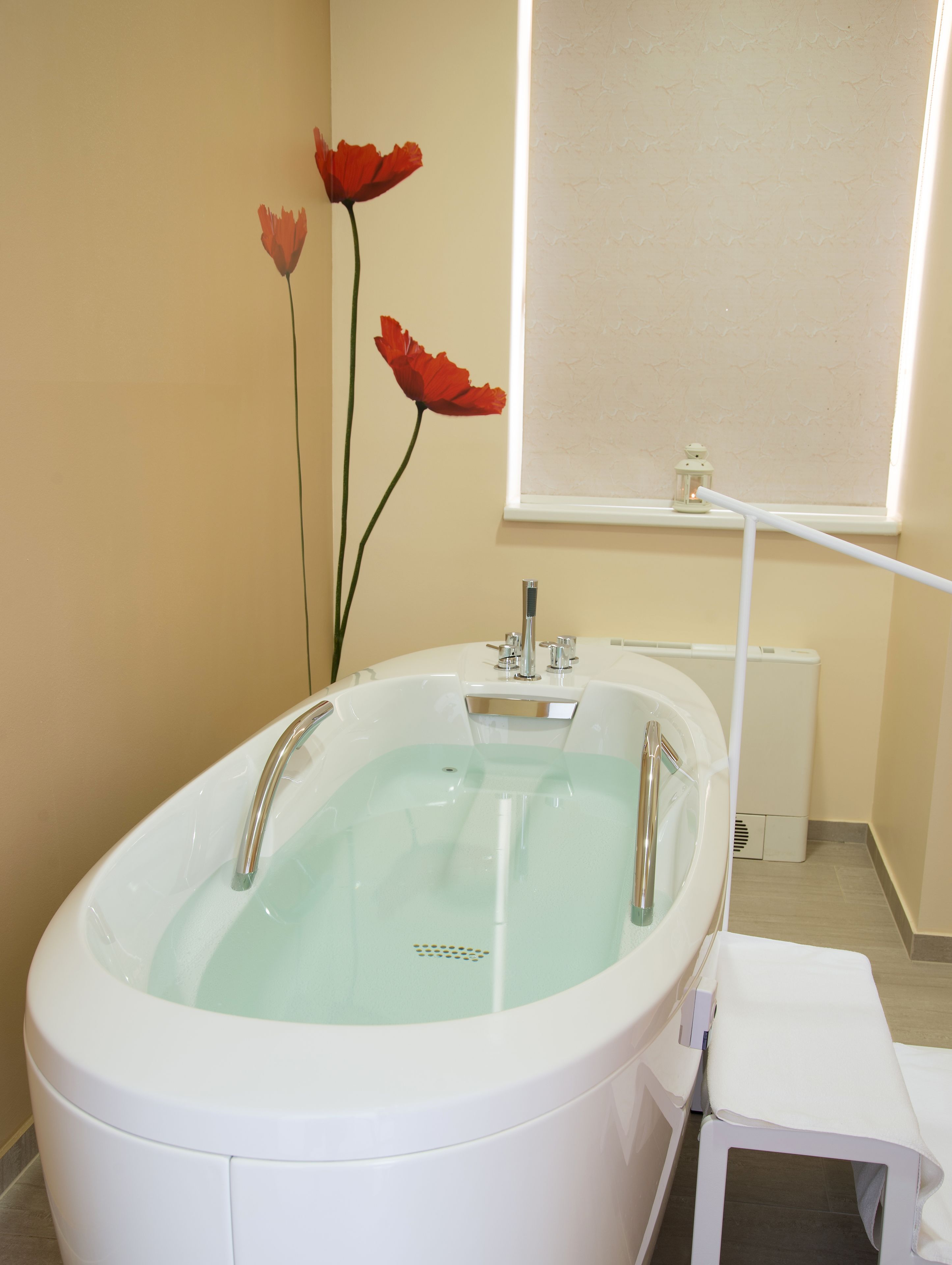 Un baño moderno con una bañera independiente, un ventanal con vistas y un banco blanco.
