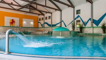 Swimmers can enjoy a refreshing dip in the pool with a diving board and stairs.