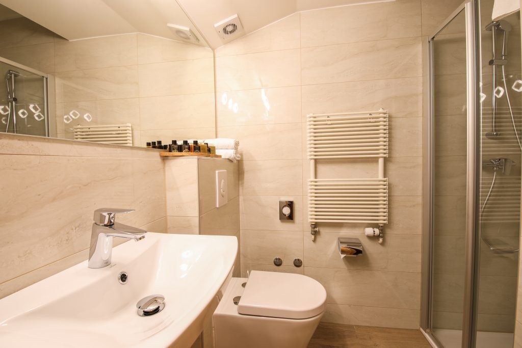 A modern bathroom with a sink, toilet, and shower.