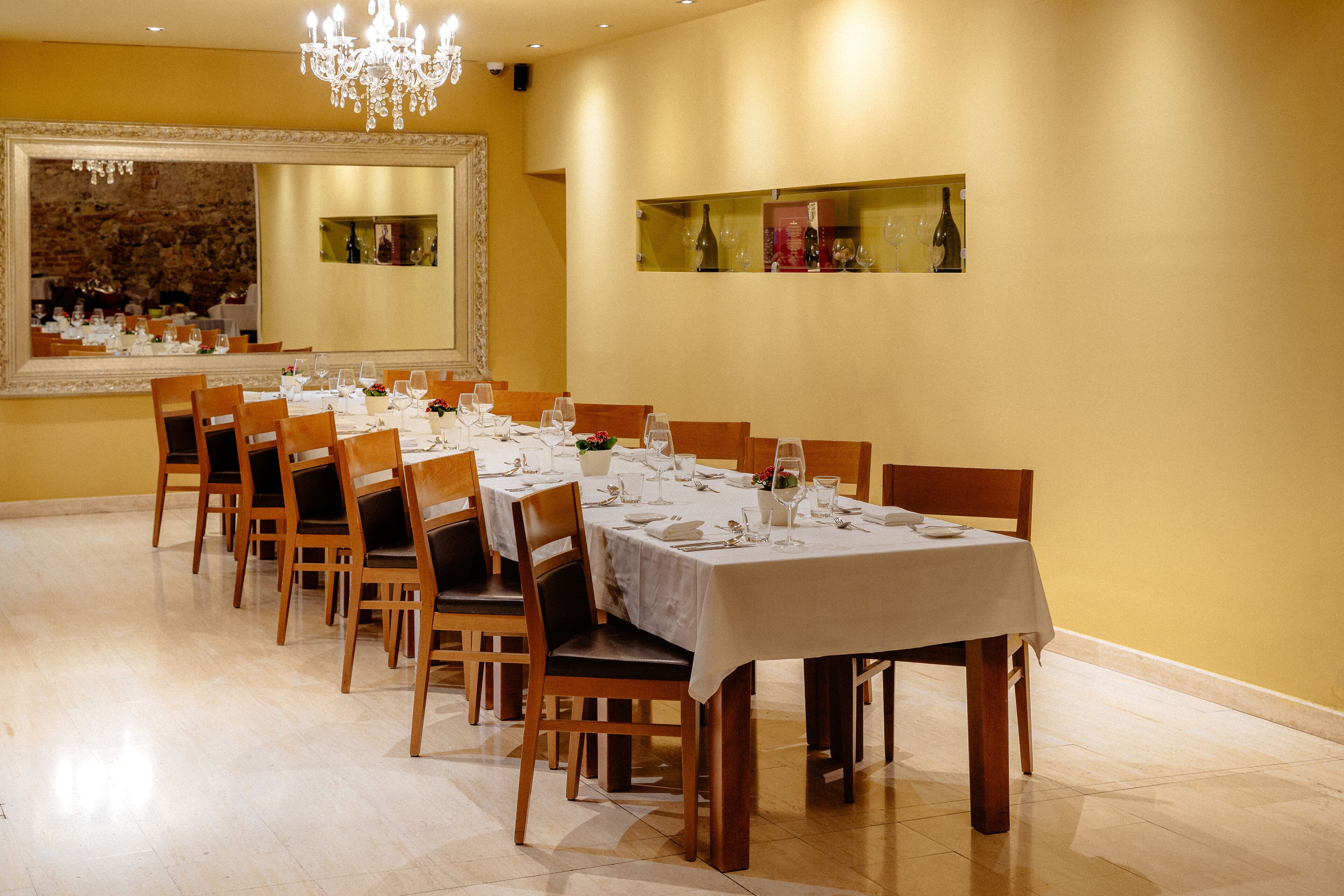 A dining area with a long table set for a meal, surrounded by chairs.
