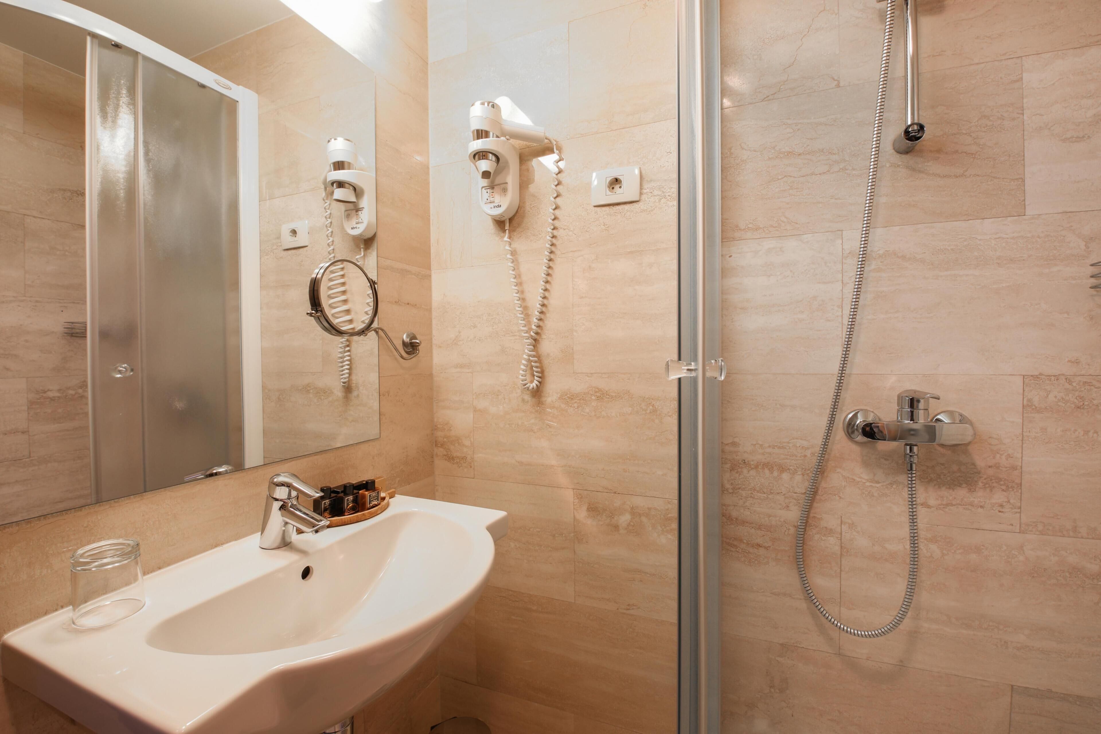 superior single room | bathroom | shower, hair dryer, slippers, towels