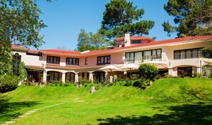 A two-story house with a red roof, large windows, and a covered patio area. - Southern Light Country House (Cape Town)