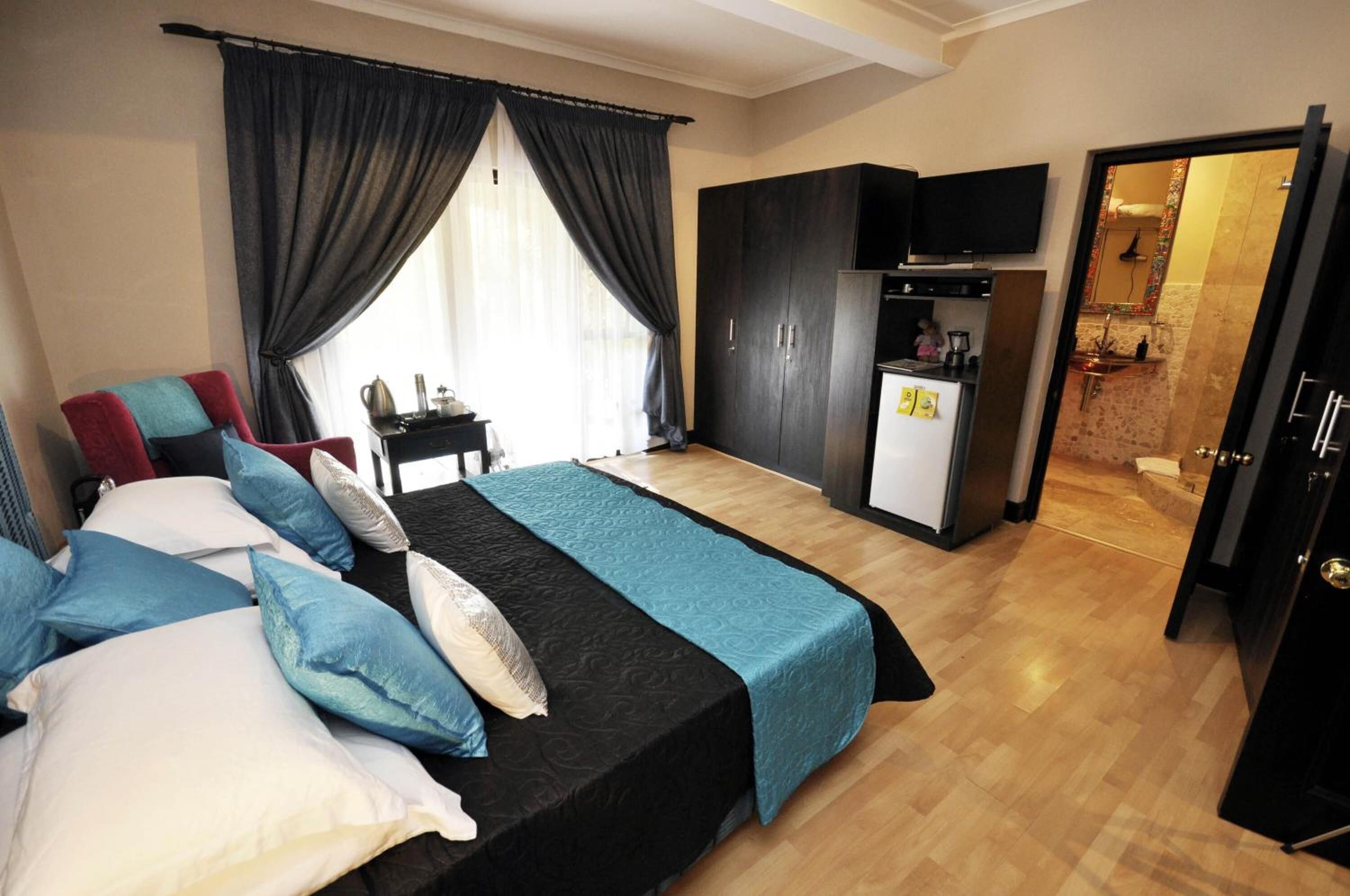 Een hotelkamer met een bed, een bureau, een kledingkast en een kitchenette.