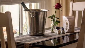 A table with a metal bucket, a vase with a single rose, and a card with names.