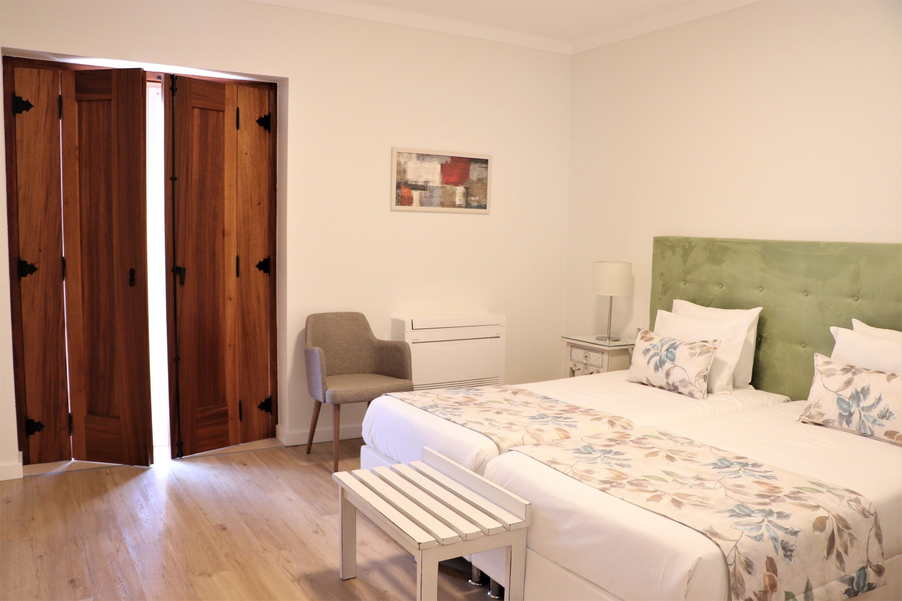Une chambre à coucher avec un lit, une chaise, un bureau et un banc.