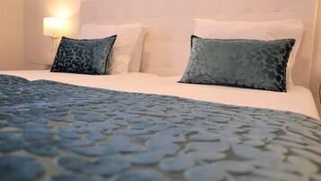 Une chambre d’hôtel avec un lit, des oreillers, une lampe et une couvre-lit à motifs.