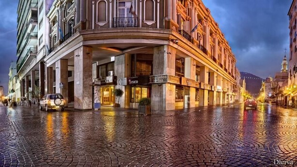 A historic building with a colonial architectural style, featuring a prominent entrance and multiple ground-floor shops.
