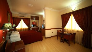 Una habitación de hotel con una cama, un escritorio, una silla, un espejo y un televisor.