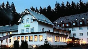 Un hotel con un llamativo letrero que dice 'HOTEL', estilo arquitectónico tradicional con un techo empinado y numerosas ventanas.