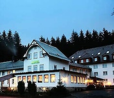 Un hotel con un llamativo letrero que dice 'HOTEL', estilo arquitectónico tradicional con un techo empinado y numerosas ventanas.