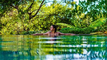 Una piscina al aire libre, sillones reclinables de piscina