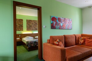 Una habitación de hotel con una cama, un sofá y dos cuadros en la pared.