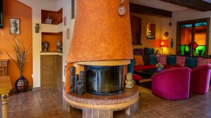 Una sala acogedora con chimenea, un sofá y varios objetos decorativos.