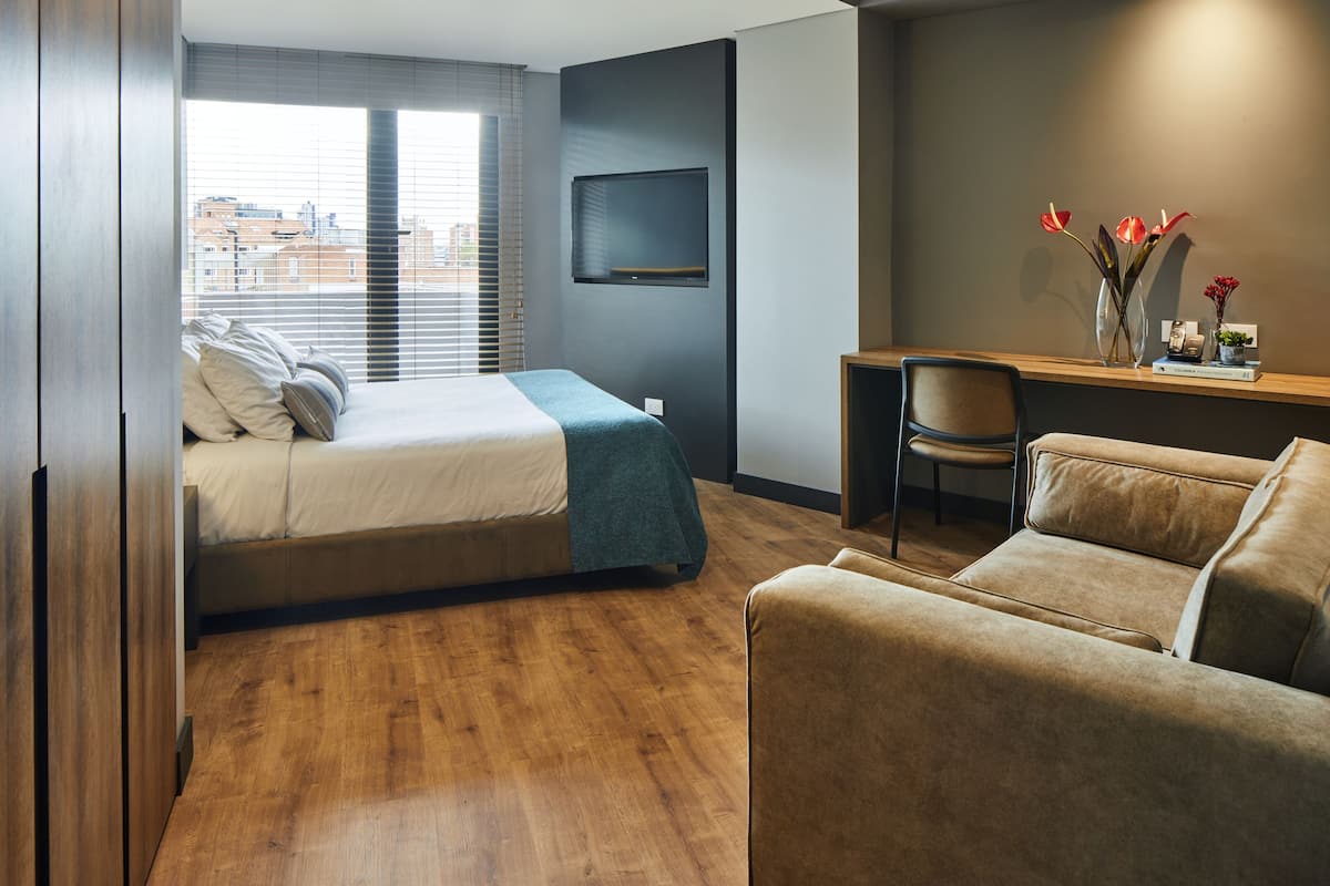 Um quarto moderno com uma cama, uma escrivaninha e uma cadeira.