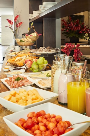 A buffet spread with various food items and beverages. - Nico ApartaSuites (Bogotá)