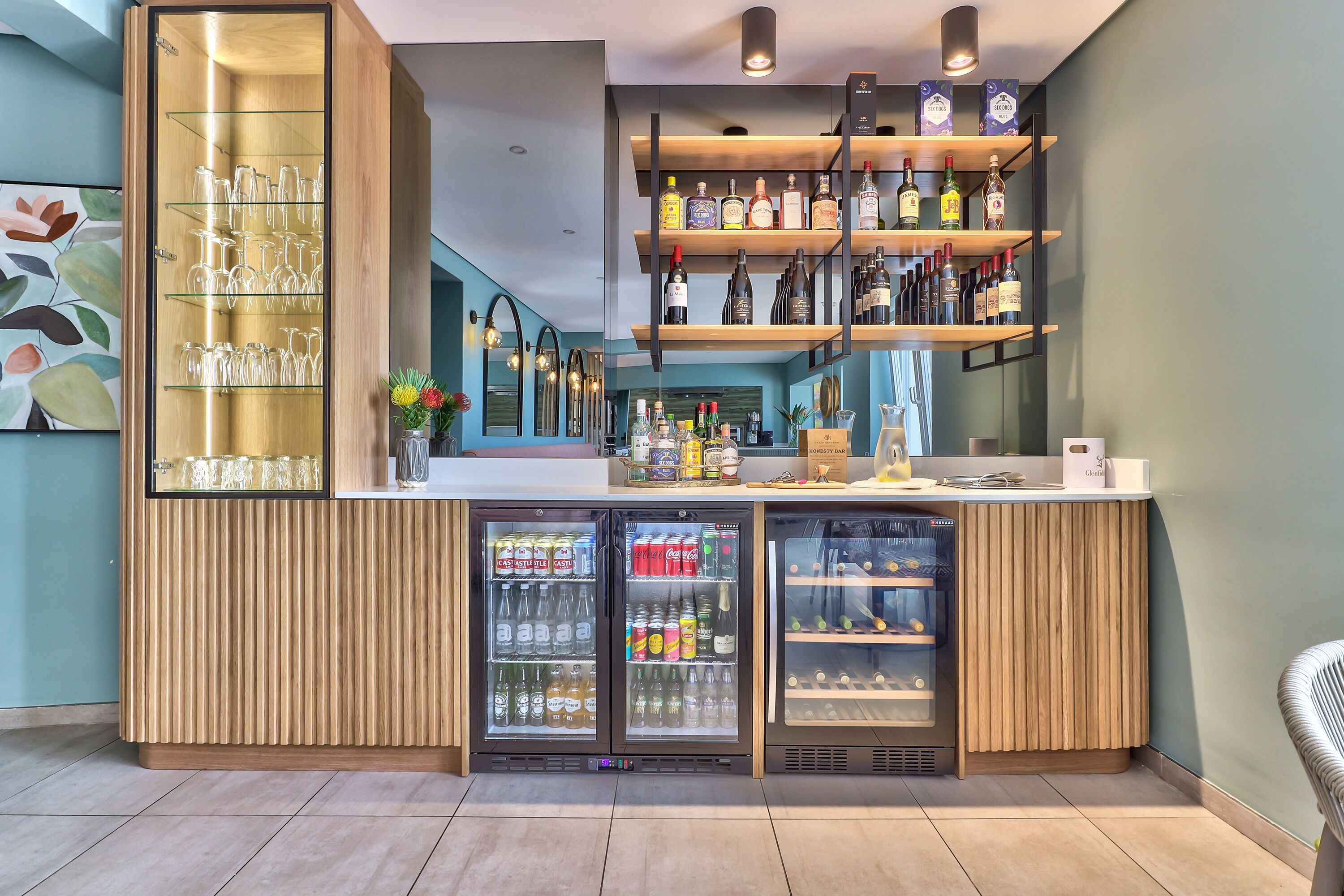 Een bar met flessenkasten, een koeltoog en een glaswerkrek.