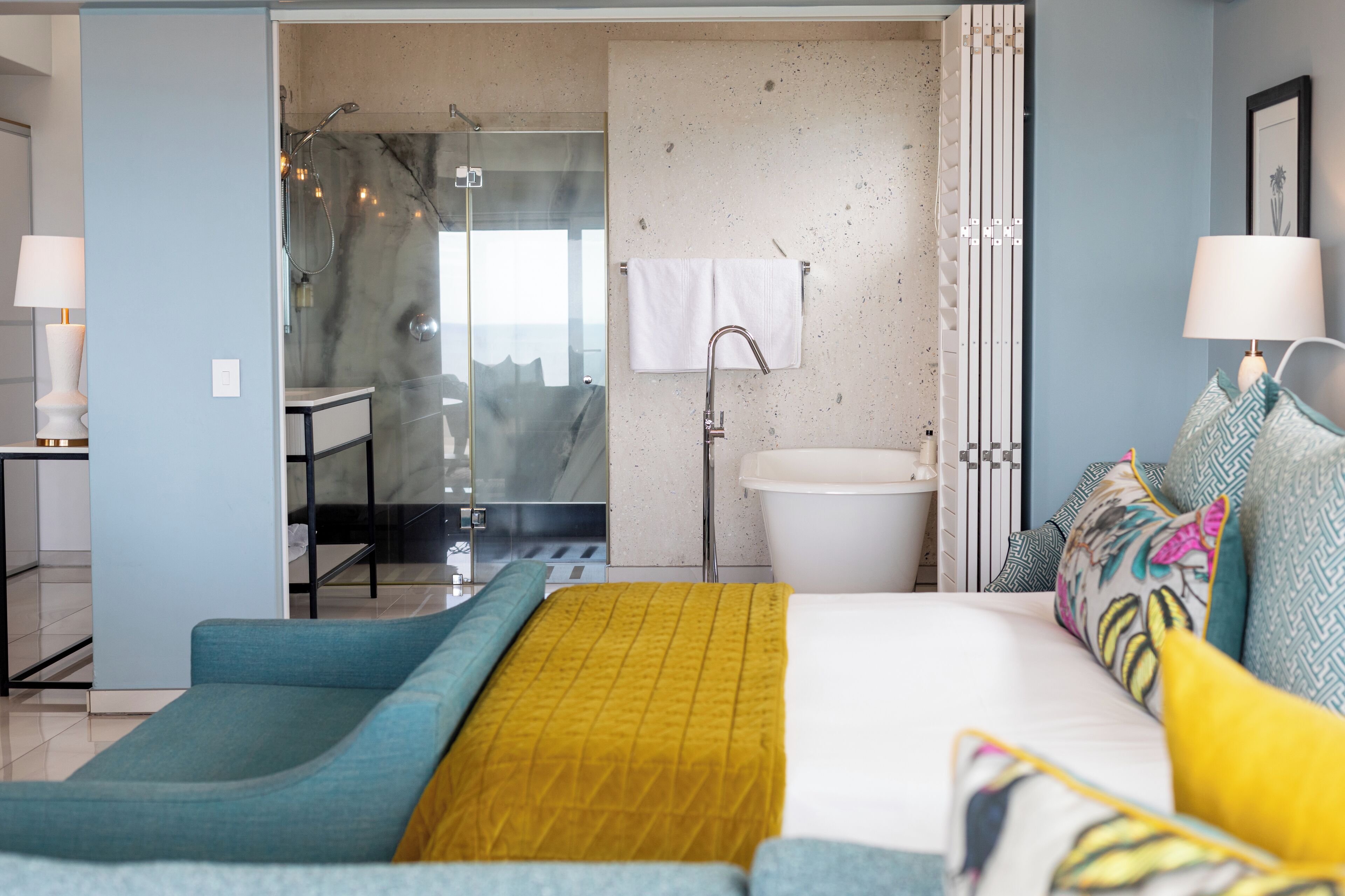 Une chambre moderne comprenant un lit, une salle de bain et un coin salon.