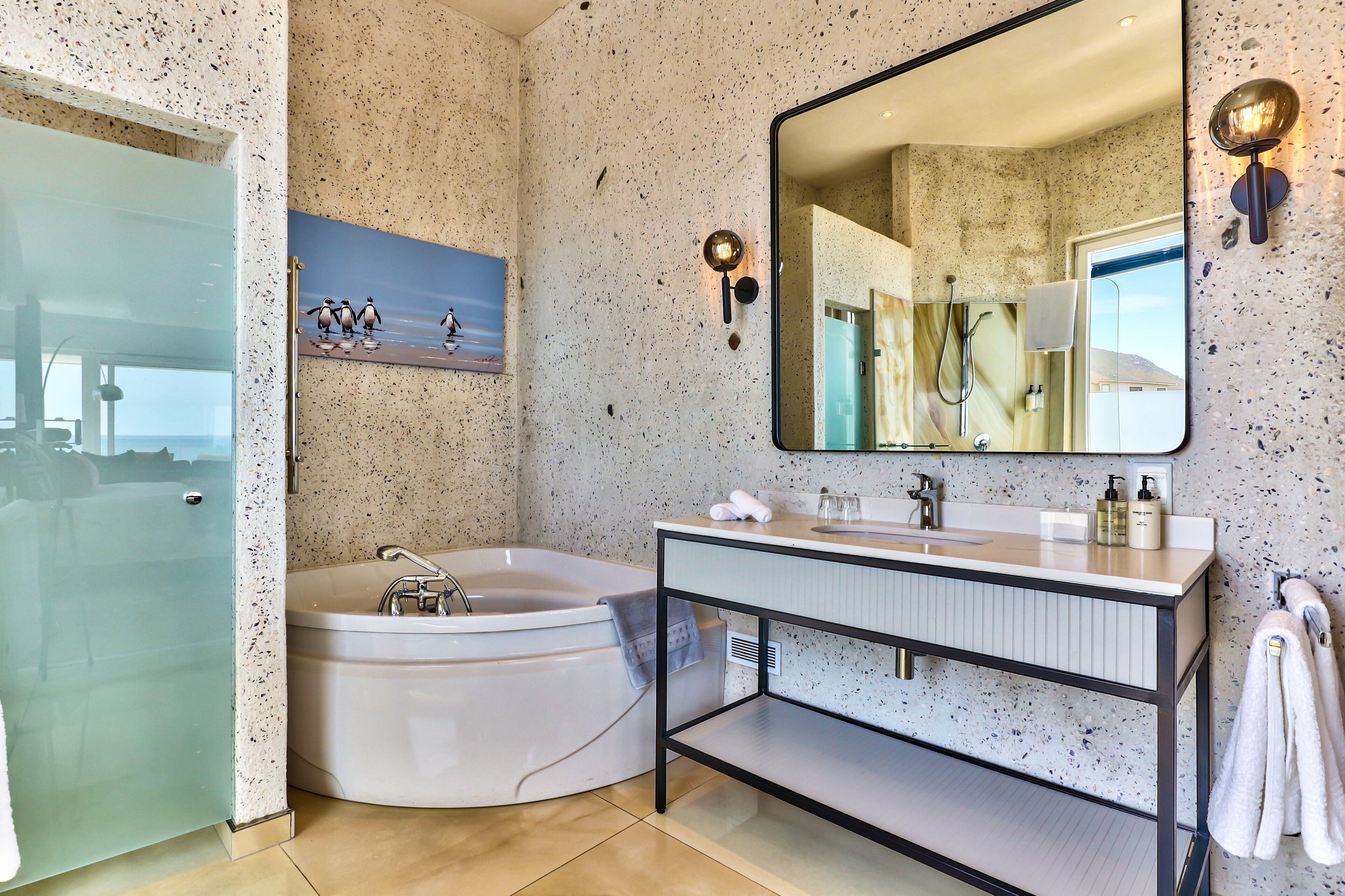 A modern bathroom with a freestanding bathtub, a large mirror, and a vanity with a countertop.