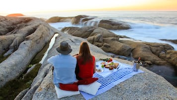 Enjoy a serene meal on a scenic rocky outcrop overlooking the water.