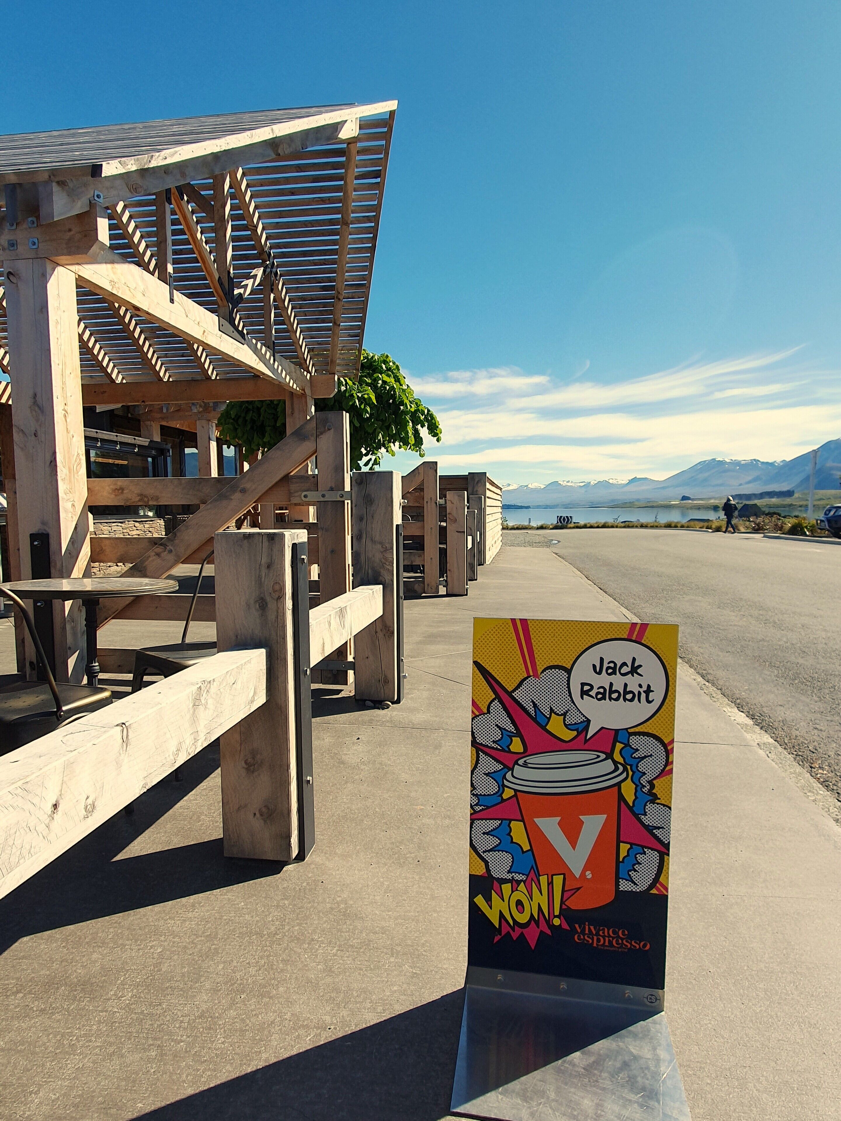 A wooden structure with a metal roof, possibly a café or restaurant, with a sign for Jack Rabbit Espresso.