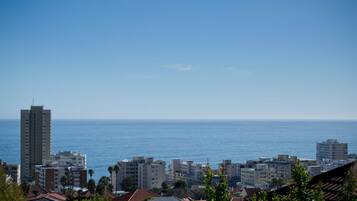 A coastal cityscape with buildings and a clear view of the ocean.
