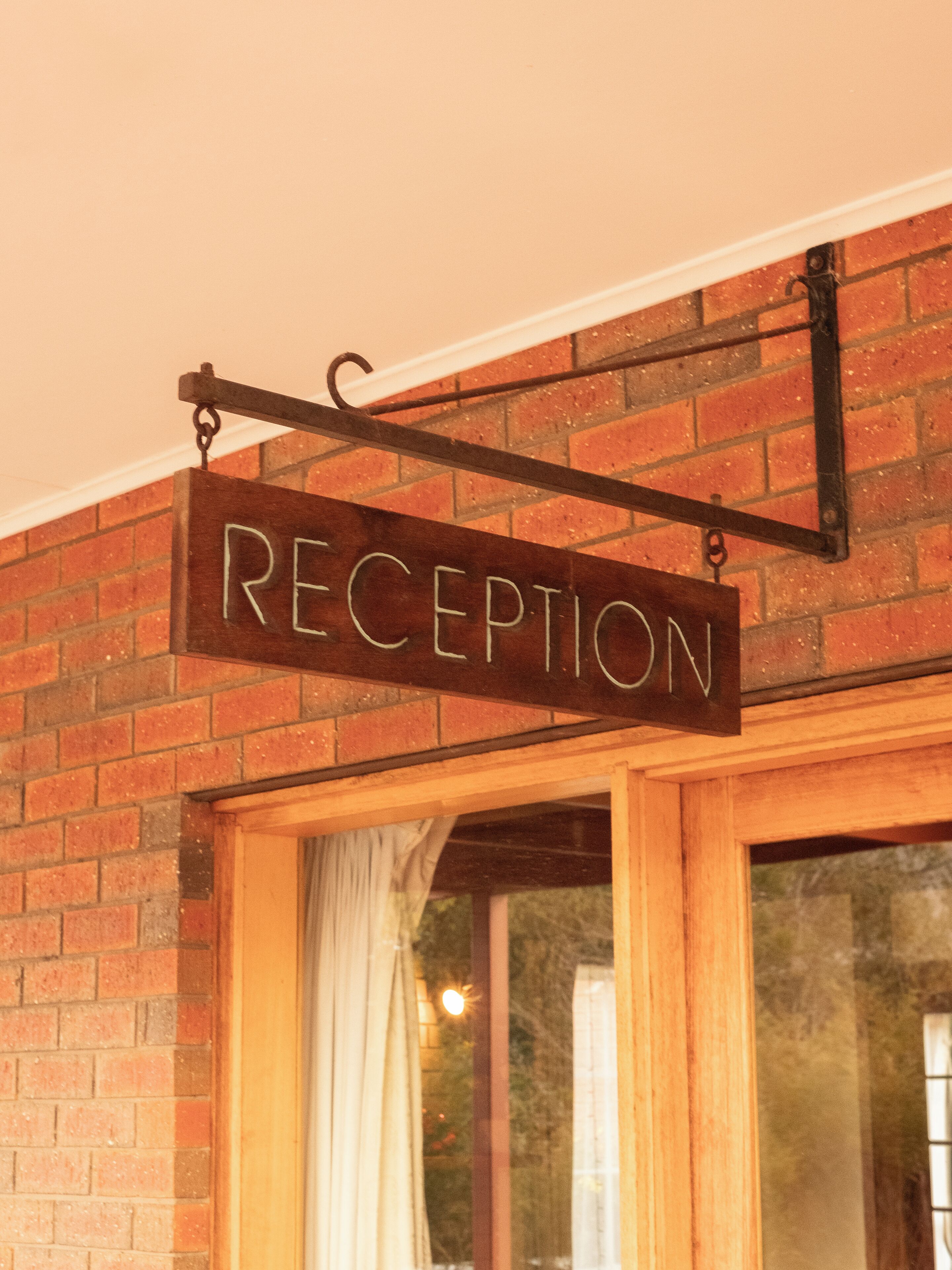 A reception sign mounted on a brick wall.