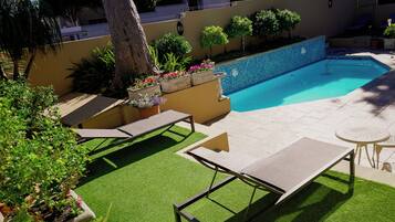 Piscine extérieure, parasols de plage, chaises longues