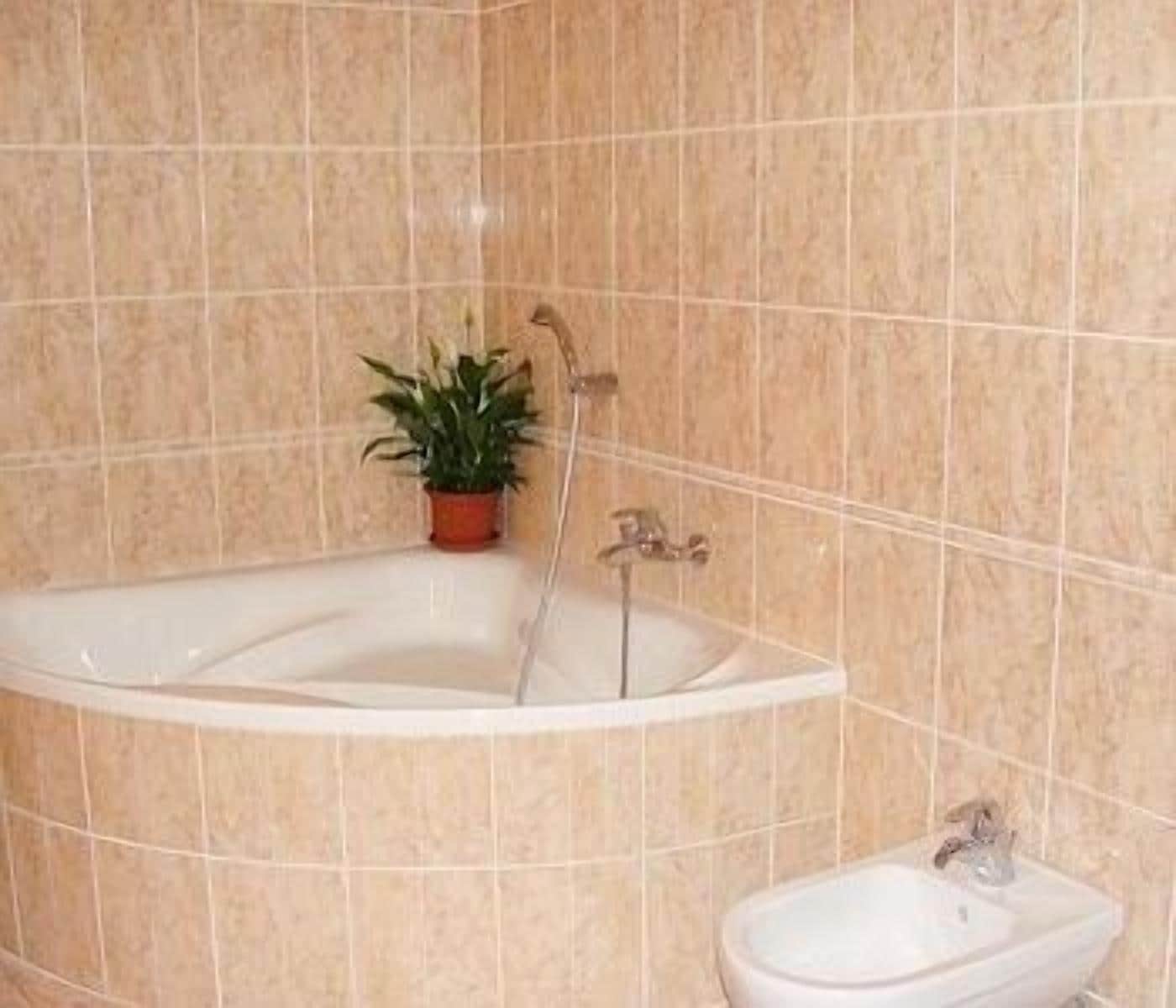 A bathroom with a freestanding bathtub, a sink, and a potted plant.