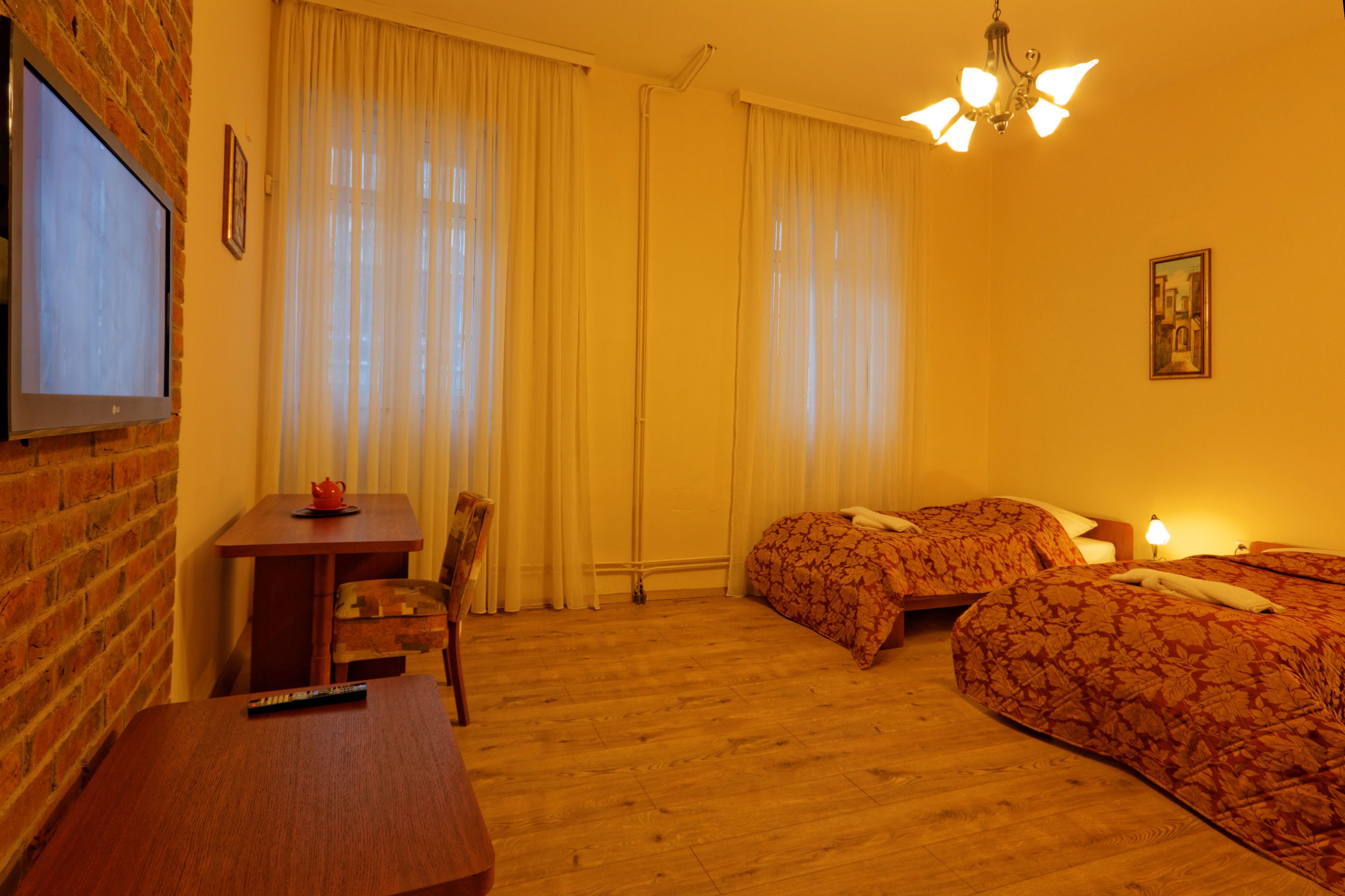 Habitació d'hotel amb dos llits, televisió, escriptori i cadira.