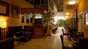A hotel lobby with a reception desk, seating area, and potted plants. - Enjoy Inn (Plzen)
