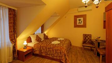 A bedroom with a bed, nightstand, chair, and table.