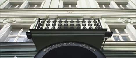 A building with a large, ornate entrance featuring a black archway and a balcony above.