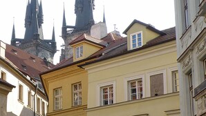 Eine Kopfsteinpflasterstraße mit historischen Gebäuden, darunter ein gelbes Gebäude mit einem Schild und einem Verbotsschild.