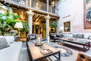 A spacious lobby with a high ceiling, a balcony, and a large painting on the wall.