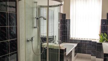 A modern bathroom with a curved glass shower enclosure, a sink, and a vanity.