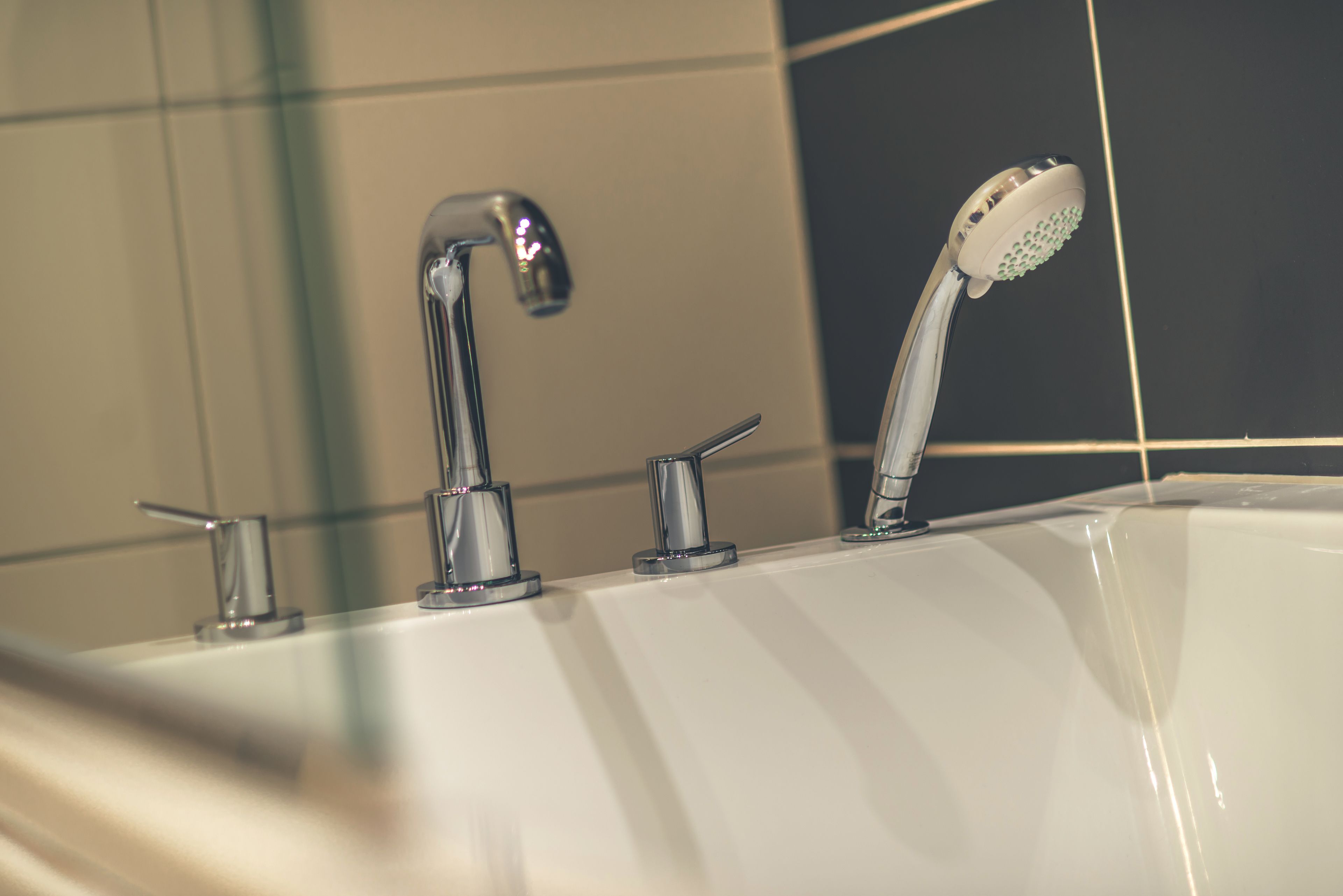 Ein Badezimmer mit einer weißen Badewanne, einer Chrom-Dusche und einem Chrom-Wasserhahn.