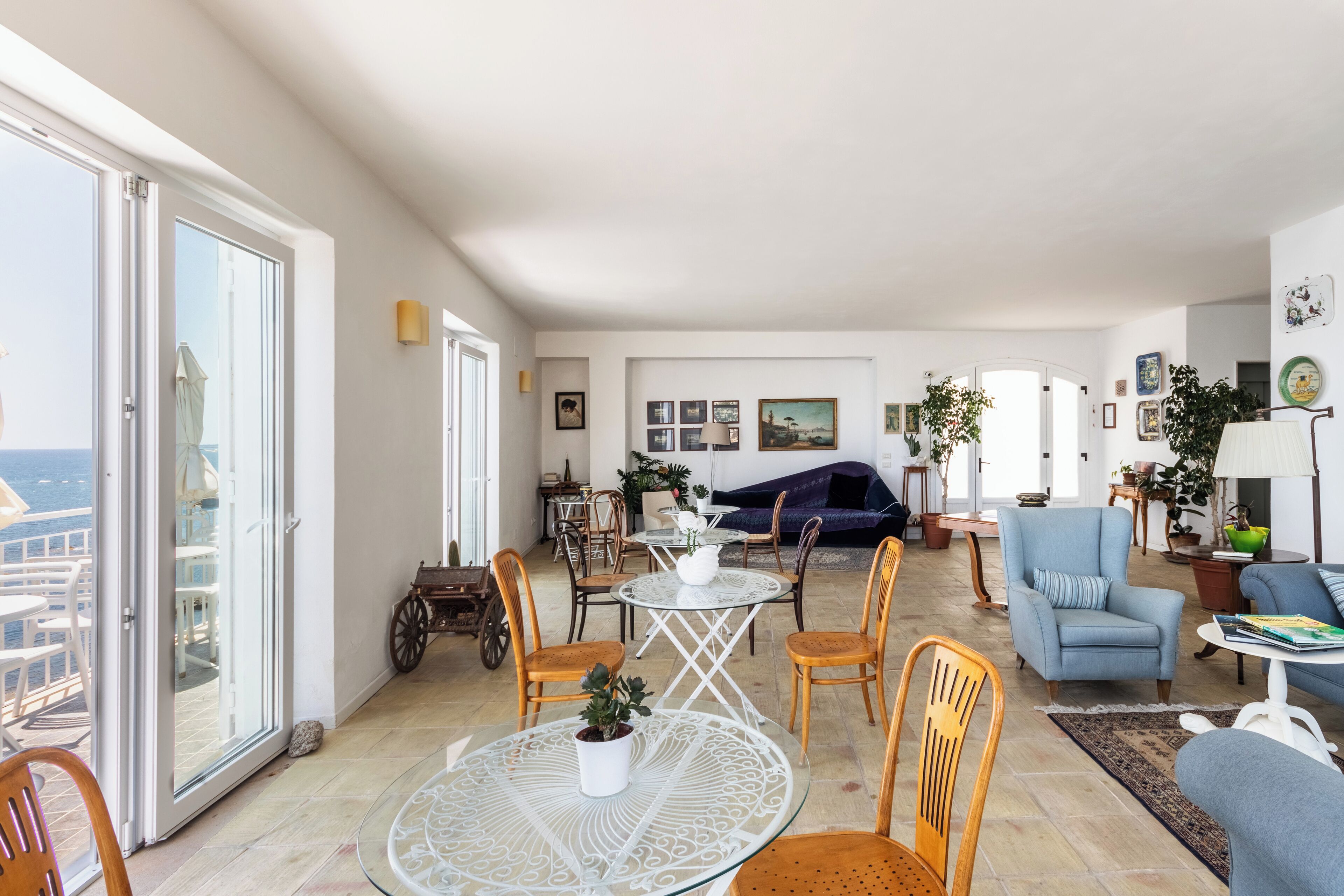 Een ruime woonkamer met balkon, eettafel en comfortabele zithoek.