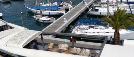 A marina with boats docked, a sushi bar, and outdoor seating.