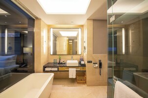 Casa de banho moderna com um espelho grande, banheira, chuveiro e toucador com lavatório e porta-toalhas.