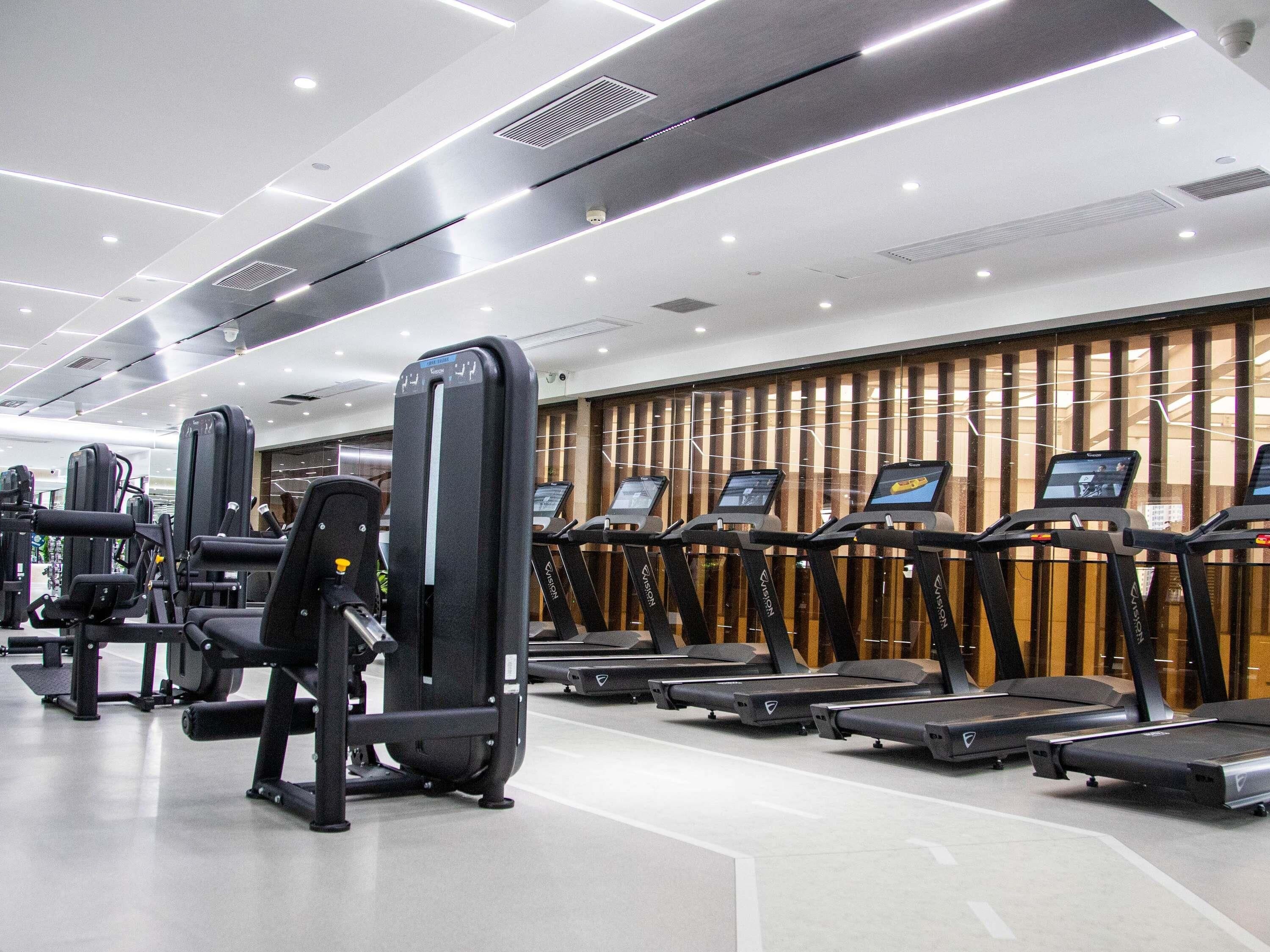 A modern gym with various exercise equipment, including treadmills and weight machines.