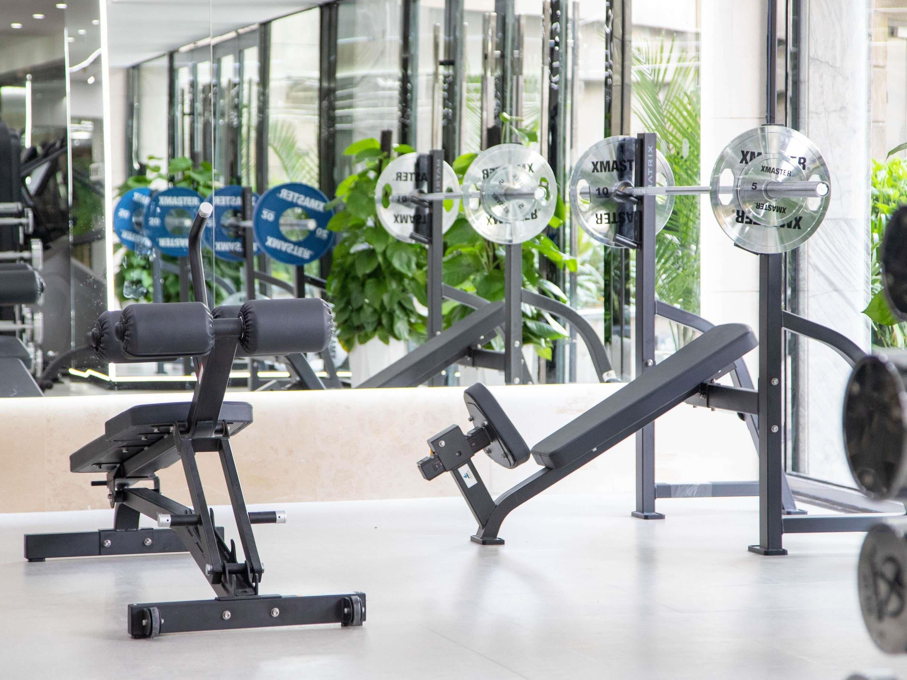 A gym with weightlifting equipment, including dumbbells and weight plates.